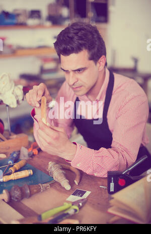 Adulto carpenter il lavoro in studio e utilizzando gli strumenti per la lavorazione del legno Foto Stock