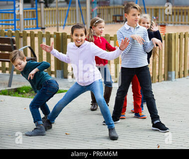 Deliberando gioco con felice allegro ai bambini di prestazioni all'aperto in autunno Foto Stock