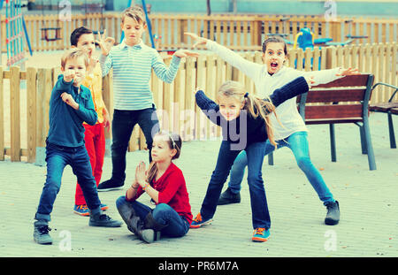 Deliberando gioco con bambini felici rendendo le prestazioni all'aperto in autunno Foto Stock