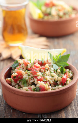 Tabulé con bulgur, pomodori, prezzemolo, menta, e limone Foto Stock