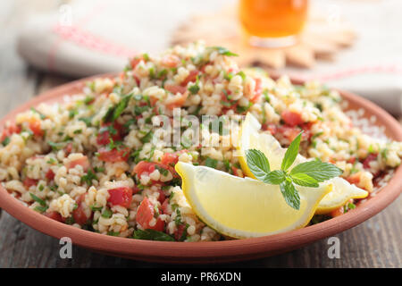Tabulé con bulgur, pomodori, prezzemolo, menta, e limone Foto Stock