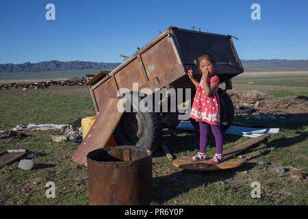 Una bambina guardando la telecamera fuori dalla sua casa vicino al Khongoryn Els le dune di sabbia del Gobi Gurvansaikhan National Park in Mongolia. Foto Stock