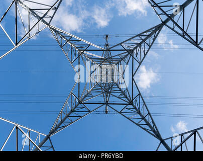 Guardando verticalmente verso l'alto dal centro di una distribuzione di elettricità pilone, England, Regno Unito Foto Stock