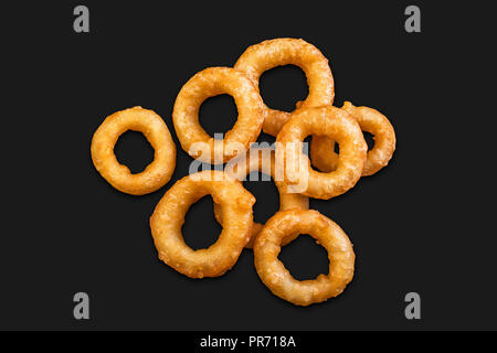 Un lotto di calamari in pastella isolata su uno sfondo nero Foto Stock