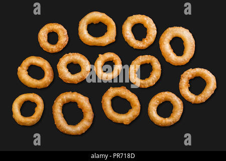 Un lotto di calamari in pastella isolata su uno sfondo nero Foto Stock