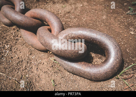 Fine del big rusty catena di ancoraggio sul pavimento closeup - Foto Stock