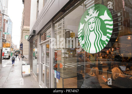 I clienti a riempire l'uno Starbucks sulla Fifth Avenue a New York City in un nuvoloso mattina di settembre. Foto Stock