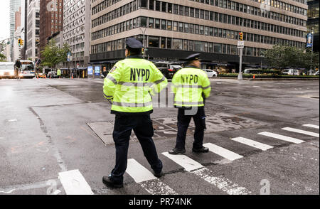 New York City i funzionari di polizia del traffico diretto all'intersezione di Park Avenue e East 57th Street in una piovosa mattinata. Foto Stock