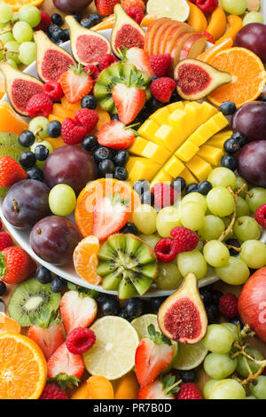 Varietà di materie sani frutti e bacche di sfondo, Fragole Lamponi arance Prugne Mele Kiwi uve mirtilli, mango Foto Stock