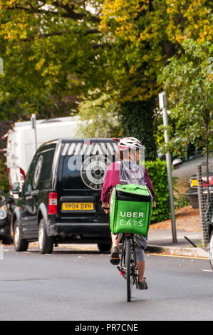 Un Uber mangia ciclista di consegna a Londra. Foto Stock