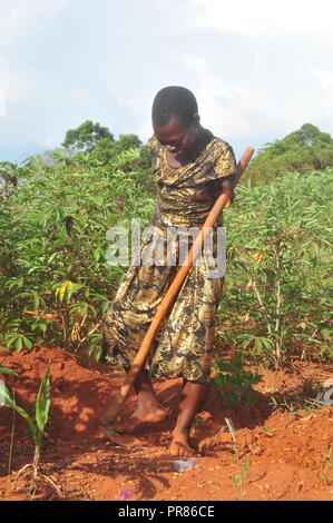 Buyende, Uganda. 29th, Settembre, 2018. Nambi Scovia da 42 anni residente del villaggio di Butaaswa nel quartiere Buyende comprovanti che la disabilità non è incapacità come stava usando le sue gambe di alghe nel suo giardino di manioca. Questo è stato prima che le celebrazioni del suo 42o compleanno con il Ministro del Turismo di Busoga unito Hellen Namutamba (non in foto) che aveva visitato il suo. Nambi, una madre di due figli, non hanno entrambi i bracci ma dimostra al mondo che lei è in grado di lavare i suoi vestiti, fare sartoria, cucinare e occuparsi del suo giardino a procurarsi il cibo. Credito: Donald Kiirya/Alamy Live News. Foto Stock