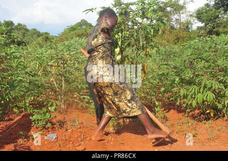 Buyende, Uganda. 29th, Settembre, 2018. Nambi Scovia da 42 anni residente del villaggio di Butaaswa nel quartiere Buyende comprovanti che la disabilità non è incapacità come stava usando le sue gambe di alghe nel suo giardino di manioca. Questo è stato prima che le celebrazioni del suo 42o compleanno con il Ministro del Turismo di Busoga unito Hellen Namutamba (non in foto) che aveva visitato il suo. Nambi, una madre di due figli, non hanno entrambi i bracci ma dimostra al mondo che lei è in grado di lavare i suoi vestiti, fare sartoria, cucinare e occuparsi del suo giardino a procurarsi il cibo. Credito: Donald Kiirya/Alamy Live News. Foto Stock