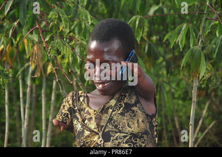 Buyende, Uganda. 29th, Settembre, 2018. Nambi Scovia da 42 anni residente del villaggio di Butaaswa nel quartiere Buyende parlando sul suo telefono dopo aver partecipato al suo giardino di manioca. Ha dimostrato che la disabilità non è di incapacità. Questo è stato prima che le celebrazioni del suo 42o compleanno con il Ministro del Turismo di Busoga unito Hellen Namutamba (non in foto) che aveva visitato il suo. Nambi, una madre di due figli, non hanno entrambi i bracci ma dimostra al mondo che lei è in grado di lavare i suoi vestiti, fare sartoria, cucinare e occuparsi del suo giardino a procurarsi il cibo. Credito: Donald Kiirya/Alamy Live News. Foto Stock