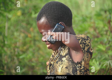 Buyende, Uganda. 29th, Settembre, 2018. Nambi Scovia da 42 anni residente del villaggio di Butaaswa nel quartiere Buyende parlando sul suo telefono dopo aver partecipato al suo giardino di manioca. Ha dimostrato che la disabilità non è di incapacità. Questo è stato prima che le celebrazioni del suo 42o compleanno con il Ministro del Turismo di Busoga unito Hellen Namutamba (non in foto) che aveva visitato il suo. Nambi, una madre di due figli, non hanno entrambi i bracci ma dimostra al mondo che lei è in grado di lavare i suoi vestiti, fare sartoria, cucinare e occuparsi del suo giardino a procurarsi il cibo. Credito: Donald Kiirya/Alamy Live News. Foto Stock