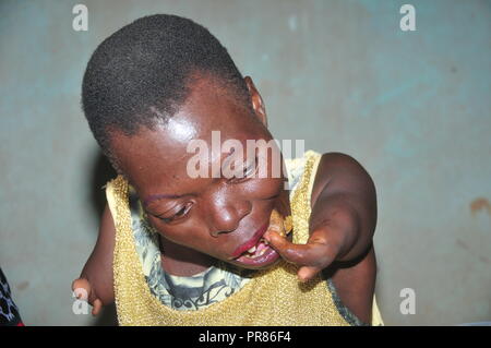 Buyende, Uganda. 29th, Settembre, 2018. Nambi Scovia da 42 anni residente del villaggio di Butaaswa nel quartiere Buyende mangiare un pezzo di carne durante le celebrazioni per il suo 42o compleanno. Nambi, una madre di due figli, non hanno entrambi i bracci ma dimostra al mondo che lei è in grado di lavare i suoi vestiti, fare sartoria, cucinare e occuparsi del suo giardino a procurarsi il cibo. Che la disabilità non è di incapacità. Credito: Donald Kiirya/Alamy Live News. Foto Stock