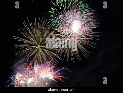 Fuochi d'artificio in diversi colori riflessi, multicolore festosi fuochi d'artificio nel cielo notturno Foto Stock