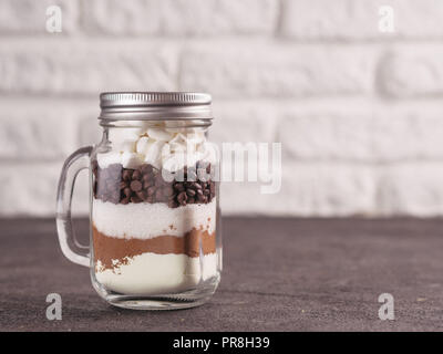 Cioccolata calda mix a mason jar. Mix fatti in casa a base di cacao, latte secco, zucchero, scaglie di cioccolato e marshmallows. Natale e vacanze inverno budget-friendly Vacanze doni idea. Spazio di copia Foto Stock