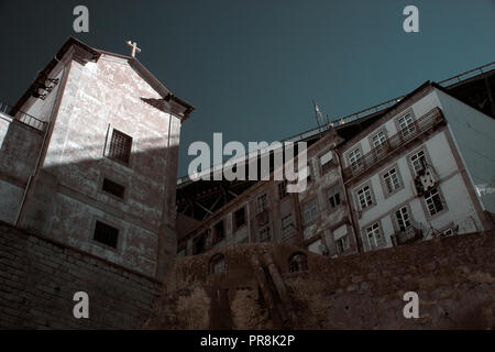 Interessante dettaglio dell'architettura del Porto di vedere il vecchio ferro da stiro brige oltre le case e la chiesa. Utilizzate il filtro a infrarossi Foto Stock