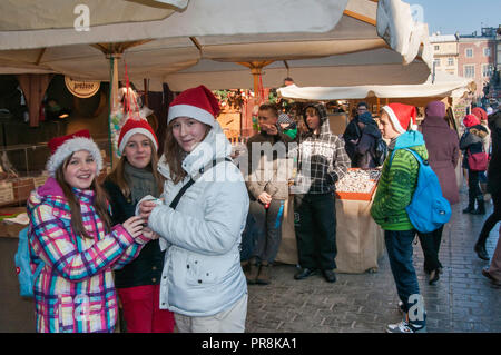 Ragazzi a Natale street fair al Rynek Glowny o la piazza principale del mercato, Cracovia in Polonia Foto Stock