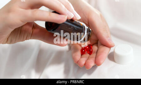 Primo piano immagine del paziente femmina tenendo una bottiglia di pillole e agitando Foto Stock