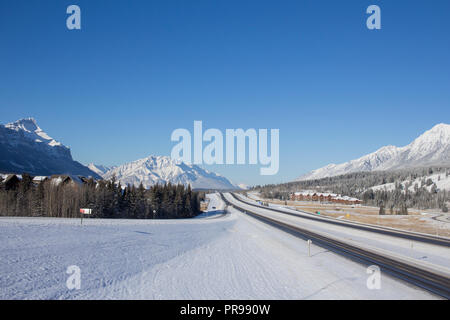 La Trans Canada highway che conduce al Parco Nazionale di Banff su un chiaro freddo giorno d'inverno. Foto Stock