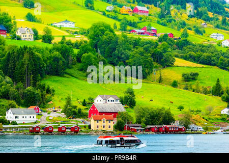 Villaggio norvegese paesaggio con fiordo, montagne e case colorate, barca in Olden, Norvegia Foto Stock