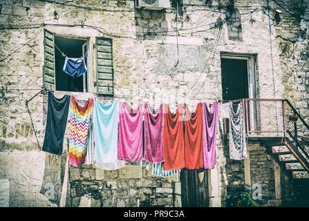 Asciugatura di fronte alla vecchia casa. Architettura mediterranea. Foto analogico filtro con graffi. Foto Stock