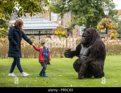 Theodore Kiaie interagisce con un gorilla di montagna animatronica a grandezza naturale del Turismo Uganda durante lo spettacolo di viaggio Wildlife & Safari al Convegno Harrogate di Harrogate, nello Yorkshire. Foto Stock