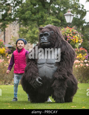 Zahra Kiaie interagisce con un gorilla di montagna animatronica a grandezza naturale del turismo ugandese durante lo spettacolo di viaggio Wildlife & Safari al Convegno Harrogate di Harrogate, nello Yorkshire. Foto Stock