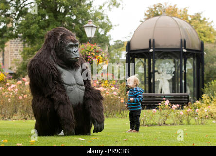 Bradley Laggar interagisce con un gorilla di montagna animatronica a grandezza naturale del turismo ugandese durante lo spettacolo di viaggio Wildlife & Safari all'Harrogate Convention di Harrogate, nello Yorkshire. Foto Stock