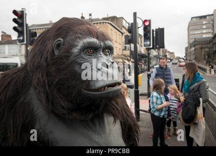 Un turismo Uganda life-size animatronic gorilla di montagna attraversa la strada al di fuori della fauna selvatica &AMP; Safari Travel Show a Harrogate Convenzione in Harrogate, Yorkshire. Foto Stock