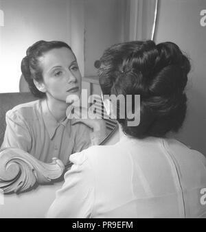 La donna nel 1940s. Un giovane dai capelli scuri donna è seduta davanti allo specchio e guardando se stessa. La Svezia 1940s. Foto Kristoffersson ref T79-5 Foto Stock