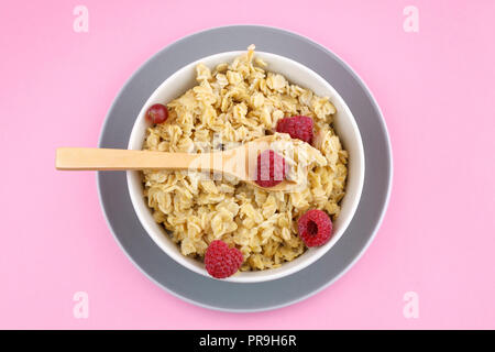 Sovraccarico di porridge su sfondo rosa Foto Stock