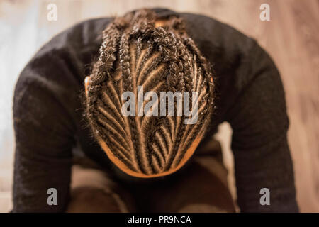 Trecce di piccole dimensioni sulla sua testa uomo con la faccia coperta, capelli scuri, Schot Foto Stock