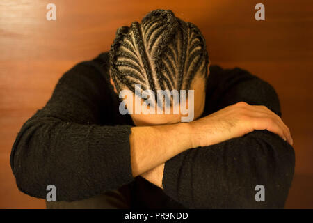 Trecce di piccole dimensioni sulla sua testa uomo con la faccia coperta, capelli scuri, Schot Foto Stock