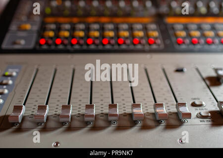 Fader di controllo. Console di miscelazione di materiali leggeri operatore al concerto. Per la registrazione del suono miscelazione in studio con scrivania da parte di un tecnico o di un produttore di musica Foto Stock