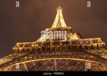 Parigi, Francia - 15 Marzo 2018: vista prospettica della torre Eiffel illuminata di notte in un nuvoloso e pioggia di notte Foto Stock
