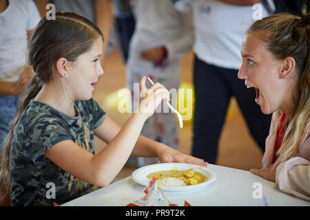 Periodo di vacanze scolastiche summer camp i bambini a mangiare la cena Foto Stock