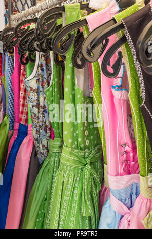 Dirndl vestiti di vari colori appendere un rack. Dirndl è un vestito tradizionale indossato in Austria e in Alto Adige e Baviera. Foto Stock