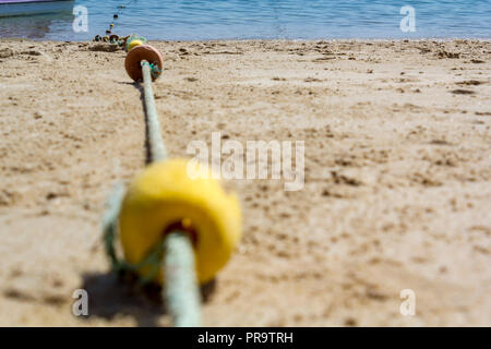 Basso angolo di vista le boe di segnalazione corda sulla spiaggia Foto Stock