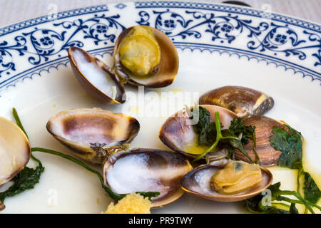 Le vongole in salsa di aglio su una piastra Foto Stock