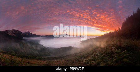 Colorato tramonto su Aramaiona valle sotto la nebbia nella provincia di Alava Foto Stock