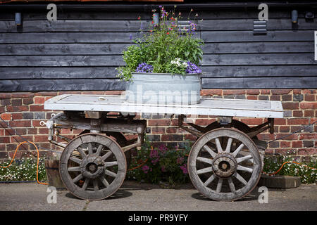 Lillibrooke Manor fienili un contenitore per fiori su un vecchio carrello utilizzato come una decorazione Foto Stock