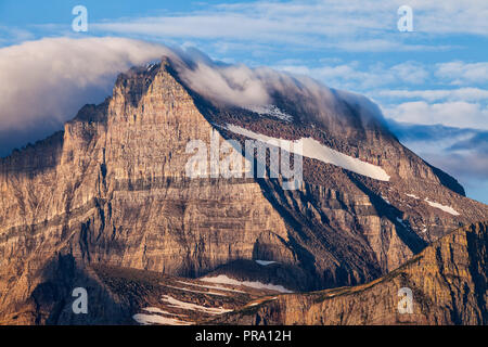 Una coltre di nubi copre un picco di montagna nel Parco Nazionale di Glacier, Montana, USA Foto Stock