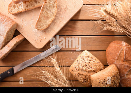 Diversi tipi di pane sulla tavola in legno rustico. Vista dall'alto. Composizione orizzontale Foto Stock