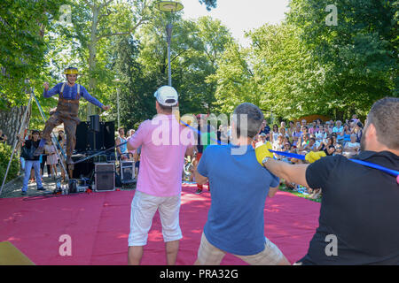 Lugano, Svizzera - 15 Luglio 2016 - uomo a camminare sulla slackline supportato da persone a Buskers Festival a Lugano, Svizzera Foto Stock