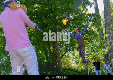 Lugano, Svizzera - 15 Luglio 2016 - uomo a camminare sulla slackline supportato da persone a Buskers Festival a Lugano, Svizzera Foto Stock