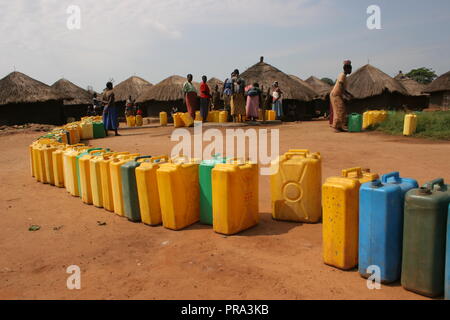 Una lunga linea di bidoni di aspettare di essere riempito in un singolo foro di trivellazione di acqua ad Atiak Persone Internamente Sfollate (IDP) camp, Uganda settentrionale. Foto Stock