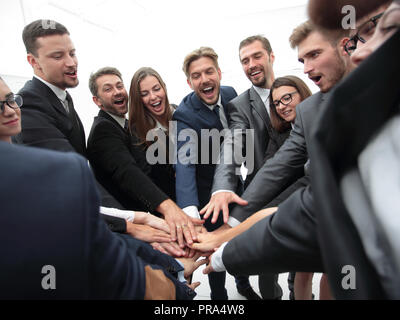 Un folto gruppo di persone di affari in piedi con le mani piegate insieme Foto Stock