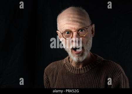 Ritratto di sorpresa senior uomo su sfondo nero Foto Stock